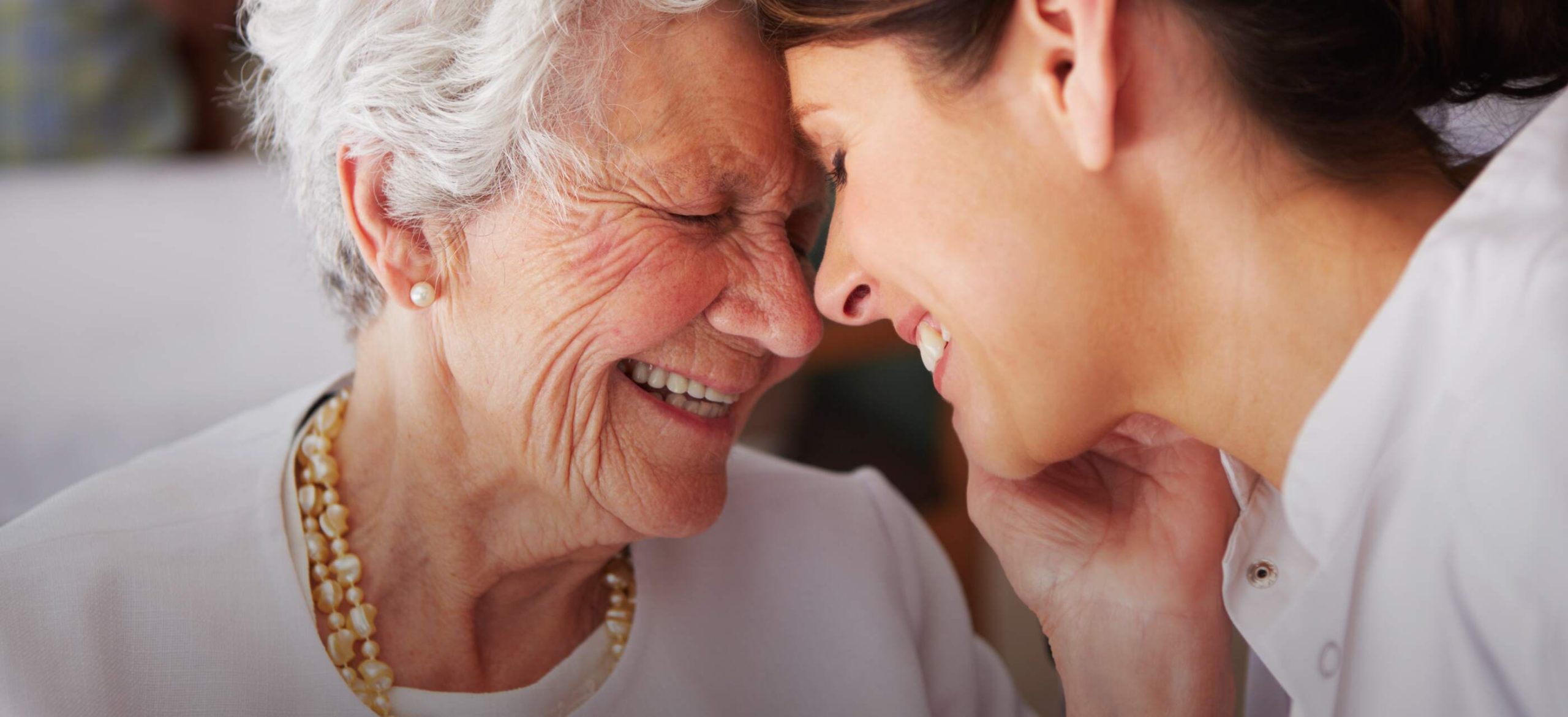 Varenita of Simi Valley memory care resident touching foreheads and smiling with younger woman