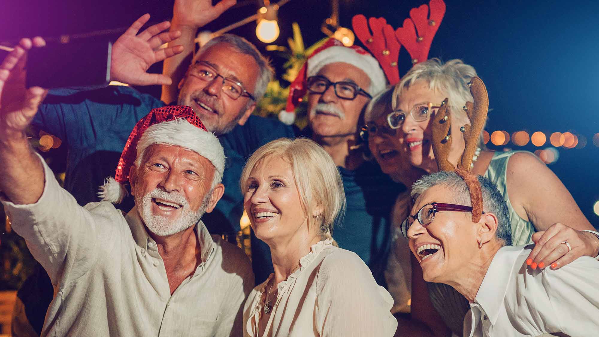 senior living residents taking selfie at a holiday party