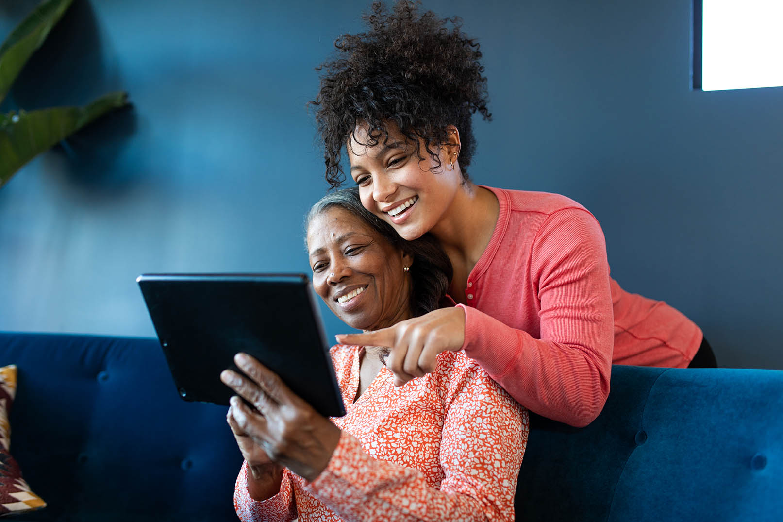 Mature black woman looking at a digital tablet together with her granddaughter