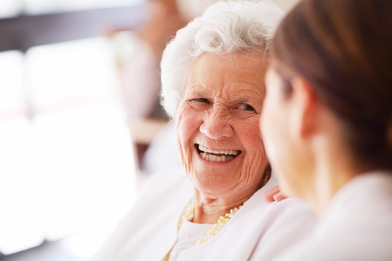 senior enjoying life in a memory care retirement home with her nurse