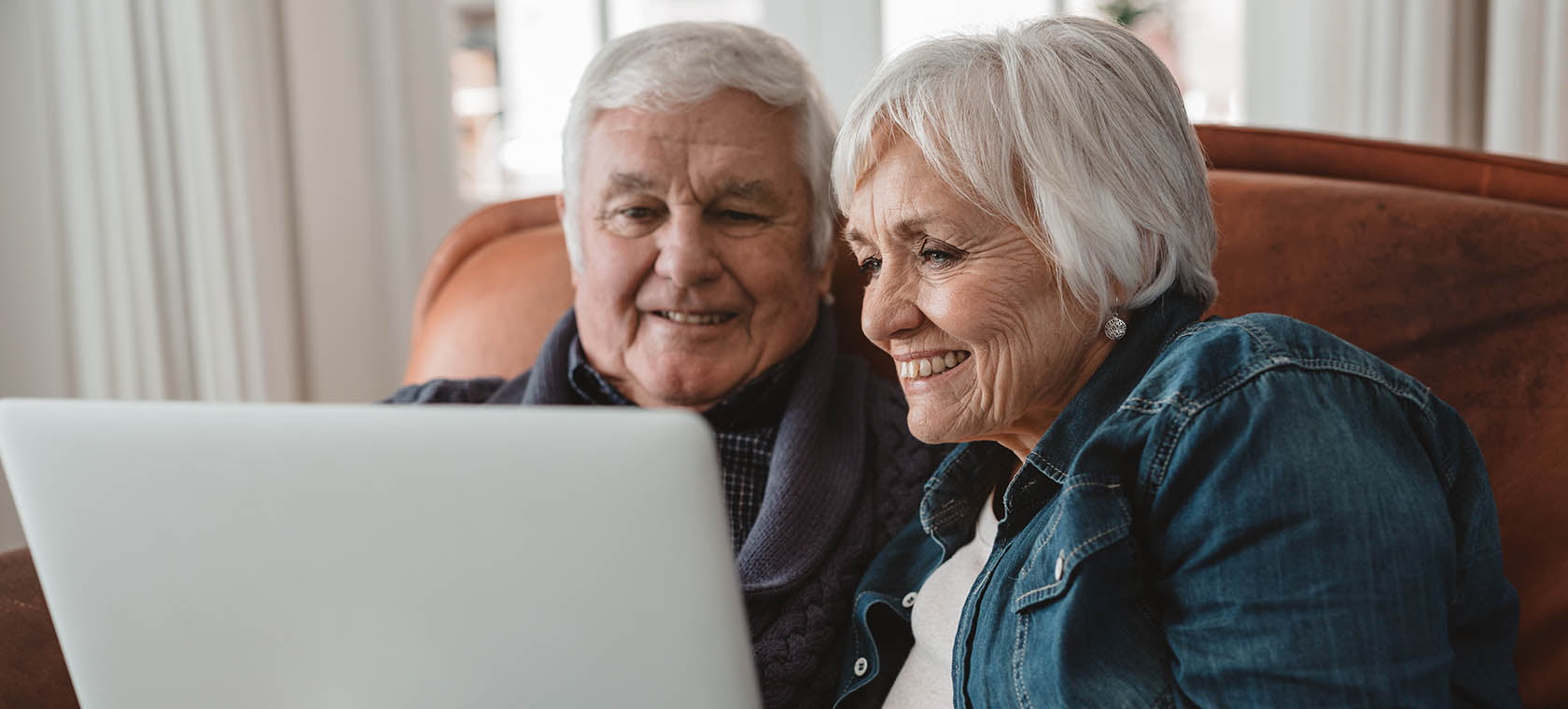 senior couple looking at senior living options for themselves on a lap top