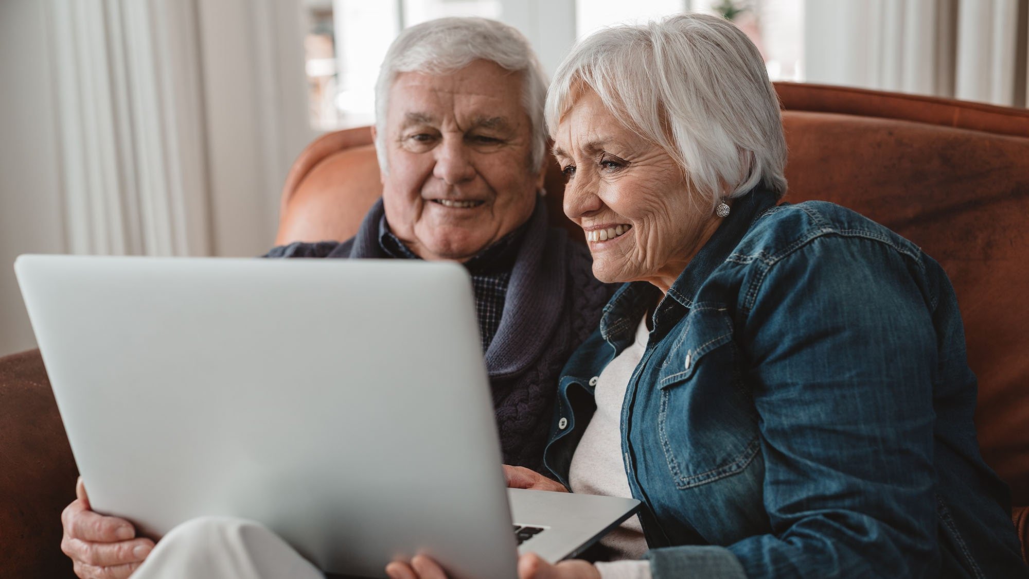 elderly couple financial planning for senior living on their laptop